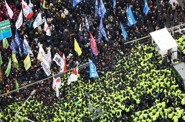 Members of the Korean Confederation of Trade Unions and other groups, calling for the impeachment of President Yoon Suk Yeol and the dissolution of the ruling People Power Party, confront police attempting to block their march toward the presidential office, near Namyeong Station in Seoul on Thursday. (Yonhap)