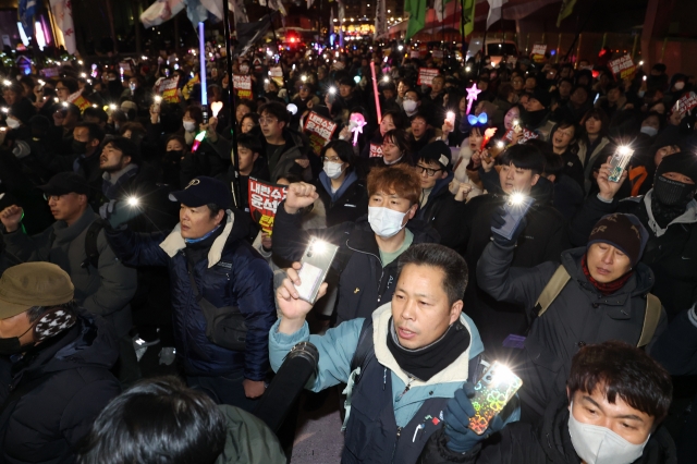 Protesters, including members of the largest labor umbrella, Korean Confederation of Trade Unions, and liberal civic groups, stand outside the presidential residence in Seoul on Thursday. (Yonhap)