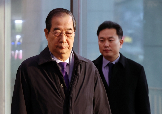 Prime Minister Han Duck-soo (left) is seen arriving to his office in Seoul on Friday. (Yonhap)