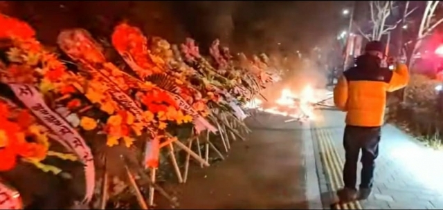 Wreaths in favor of President Yoon Suk Yeol in front of the presidential office in central Seoul are set on fire on early Sunday. (Yonhap)