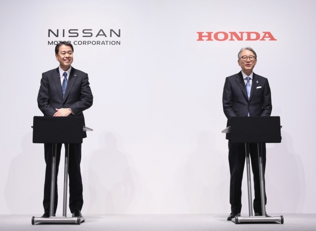 Nissan Motor CEO Makoto Uchida (left) and Honda Motor CEO Toshihiro Mibe pose for a photo during a press conference in March this year. (Honda, Nissan)