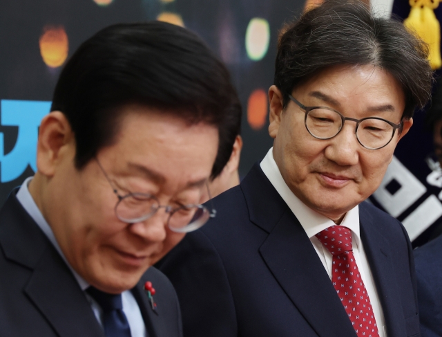 Democratic Party of Korea's Chair Rep. Lee Jae-myung (left) and People Power Party's acting Chair Rep. Kweon Seong-dong are seen during their meeting at the National Assembly on Wednesday. (Yonhap)