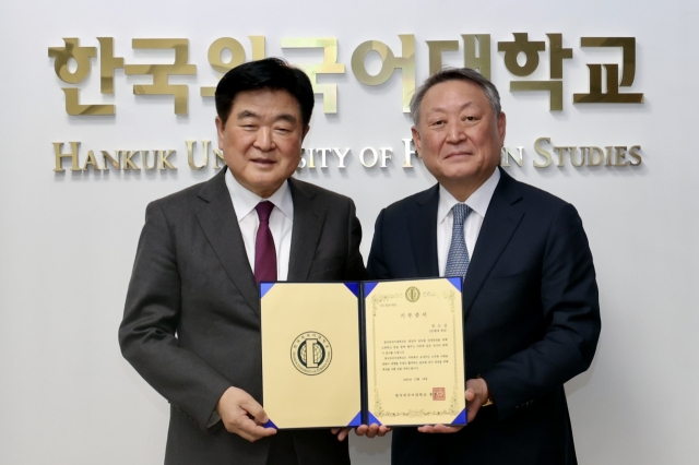 HD Hyundai Chairman Kwon Oh-gap (left) and Hankuk University of Foreign Studies President Park Jeong-woon pose for a photo during a donation ceremony at the school in Seoul on Thursday. (HD Hyundai)