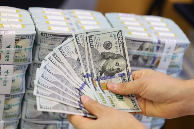 An employee arranges stacks of dollar bills at Hana Bank's Counterfeit Notes Response Center in central Seoul on Thursday. (Yonhap)