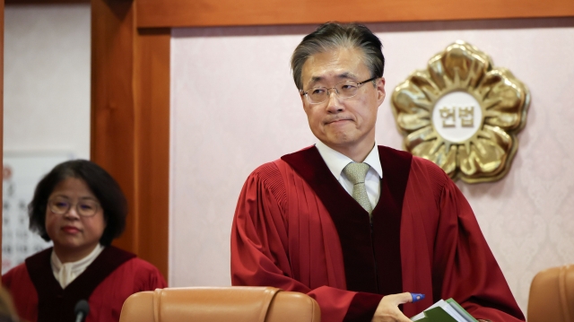 The Constitutional Court of Korea Justices Kim Bok-hyeong (left) and Kim Hyung-du enter the court for an impeachment trial in Jongno-gu, Seoul, Wednesday. (Yonhap)