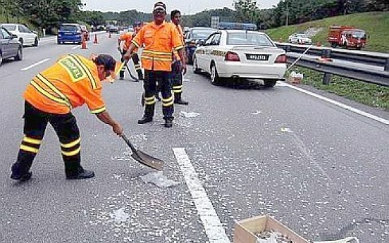 Motorists risk lives to collect coins strewn on highway