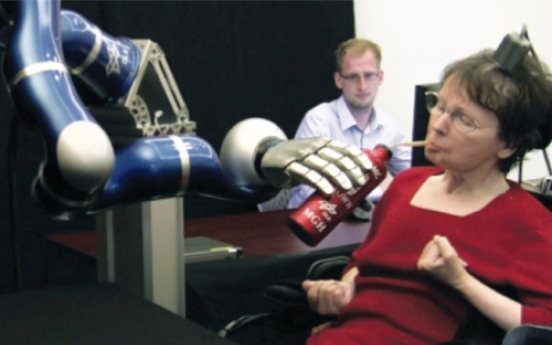 Paralyzed woman uses her mind to control robot arm