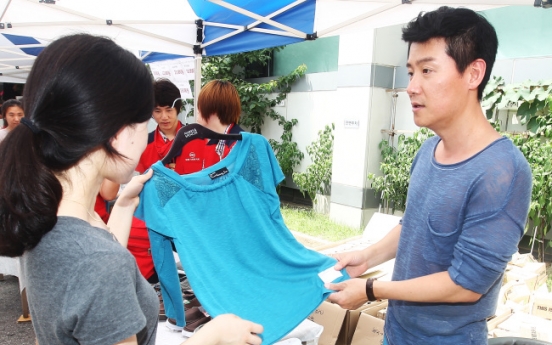 Singer Lee Hyun-woo helps out at bazaar in aid of sick children