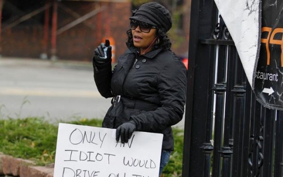 U.S. woman who drove on sidewalk holds ‘idiot’ sign