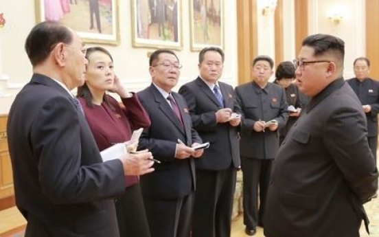 Who are nine NK officials accompanying Kim Jong-un?