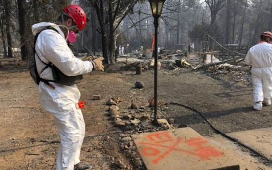 Searchers in California wildfire step up efforts before rain