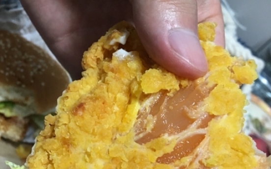 Woman bites into raw chicken burger