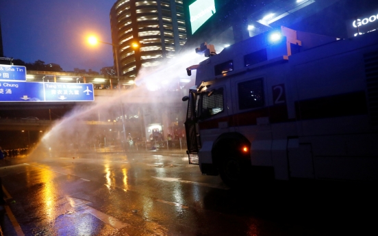 HK police say radical protesters forced use of water cannon, warning shot