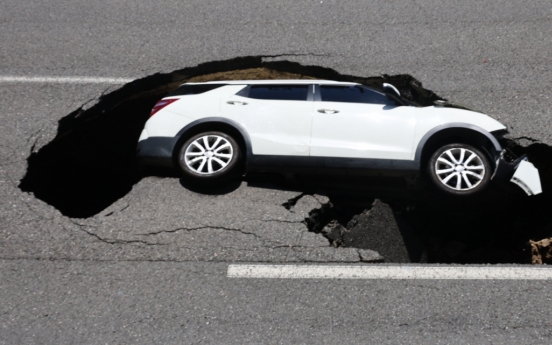 Sinkhole swallows up car, injuring 2 in Seoul