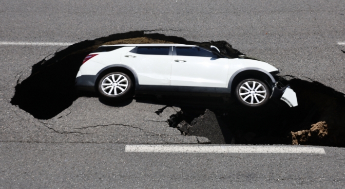 Sinkhole swallows up car, injuring 2 in Seoul