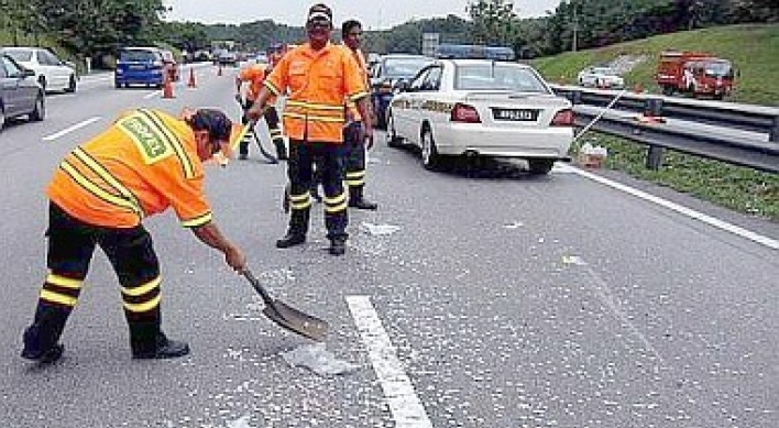 Motorists risk lives to collect coins strewn on highway