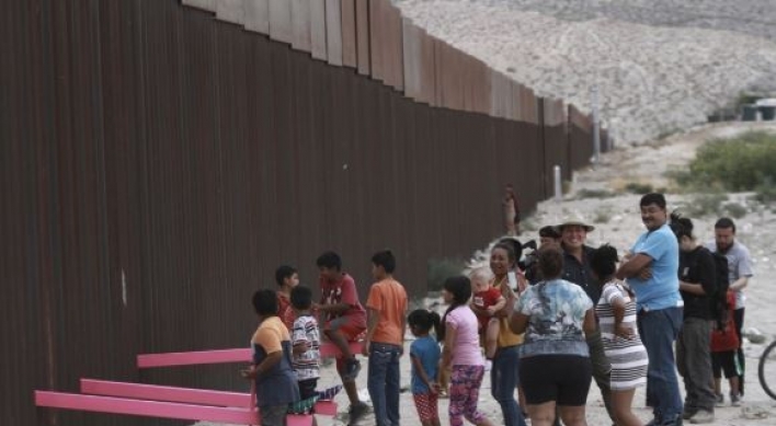 회색빛 미국-멕시코 국경에 설치된 화합의 분홍 시소