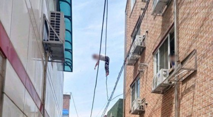 Woman dangling from power lines 6 meters above ground rescued by residents holding blanket