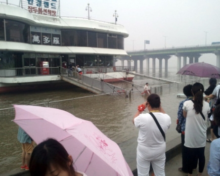 A watery supper: Chinese tourists dine at overflowing Han River