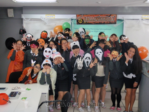 English teacher Jennifer Graham-Magill (right) and her students at Haeseong International Convention High School pose for a picture at a Halloween event in October. (Haeseong International Convention High School)