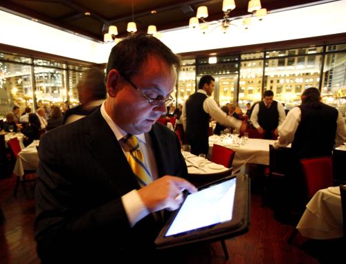 Chicago Cut steakhouse managing partner Matt Moore browses the restaurant’s wine list on an iPad in Chicago on Dec. 1. The restaurant is just one of several across the U.S. that have started uploading menus and wine lists to the digital devices. (AP-Yonhap News)