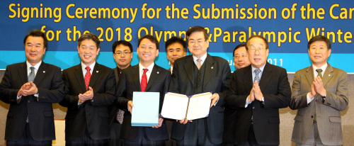 Cho Yang-ho (fourth from right), CEO of PyeongChang’s 2018 bid committee, Korean Olympic Committee president Park Yong-sung (second from right) and Lee Kwang-jae (fourth from left), governor of Gangwon Province, pose for a photo after signing the finalized 2018 Winter Olympics bid proposal in Seoul on Thursday. (Yonhap News)