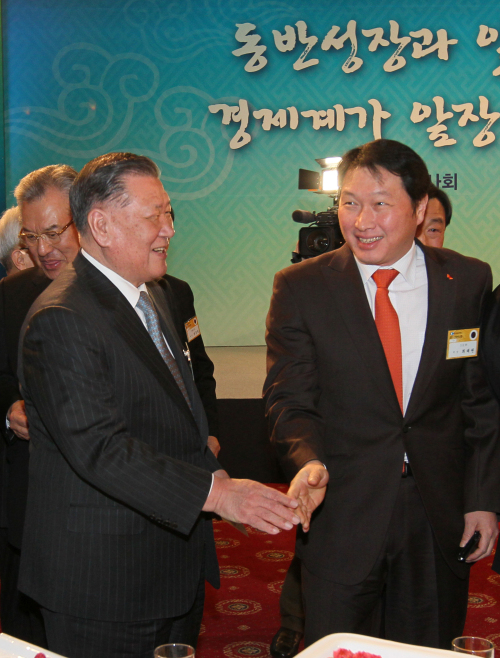 Hyundai Motor Group chairman Chung Mong-koo (left) and SK Group chairman Chey Tae-won shake hands at the Korea Chamber of Commerce and Industry’s New Year’s event for business leaders at the COEX exhibition center in Seoul on Wednesday.  (Chung Hee-cho/The Korea Herald)