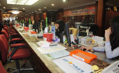 Tellers of Samhwa Savings Bank sit at their desk without customers to attend to at its headquarters in Samseong-dong, southern Seoul, on Friday. The Financial Services Commission suspended the main businesses of the distressed secondary bank.(Lee Sang-sub/The Korea Herald)