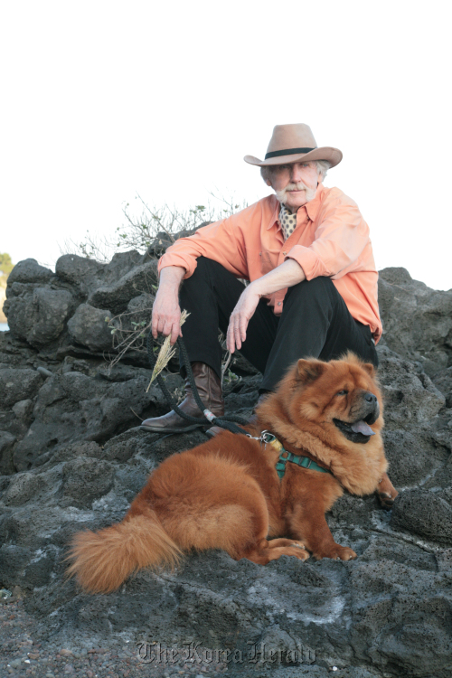 Artist Windsor Joe Innis walks his dog amongst Jeju Island’s volcanic rock formations.