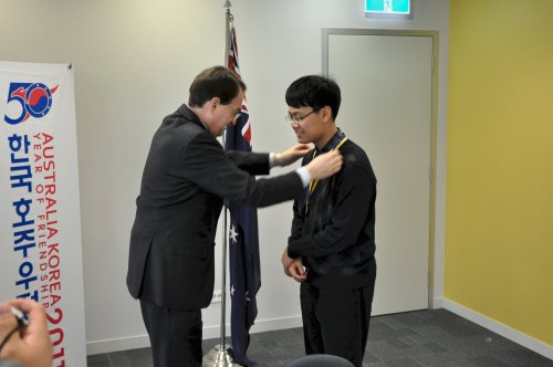 Australia Ambassador Sam Gerovich decorates Chungbuk Science High School student Ryoo Sang-woo. (Yoav Cerralbo/The Korea Herald)