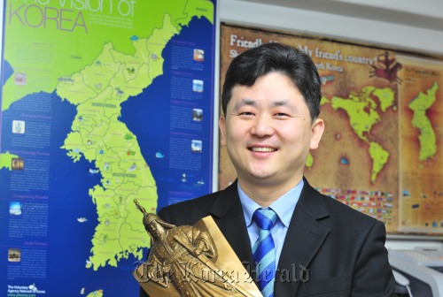 Park Gi-tae, president of Voluntary Agency Network of Korea, poses against a wall showing a Korean map in the VANK office in Seoul. (Kim Myung-sub/The Korea Herald)