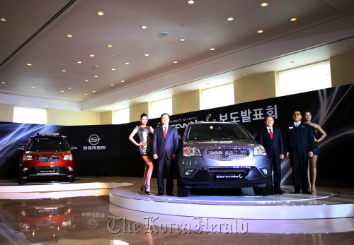 Ssangyong Motor Co. court receivership managers Lee Yoo-il (second from left) and Park Young-tae (third from right) pose with the Korando C at the launch event in Jeju on Tuesday. (Ssangyong Motor Co.)