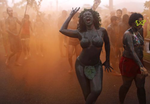 A woman dances amid orange smoke during the 'Bloco da Lama', or Mud Block carnival group parade in Paraty, Brazil, Saturday, March 5, 2011.(AP-Yonhap News)