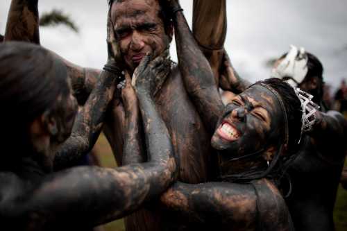 Members of the the 'Bloco da Lama', or Mud Block carnival group, cover a man in mud during carnival celebrations in Paraty, Brazil, Saturday, March 5, 2011. (AP-Yonhap News)