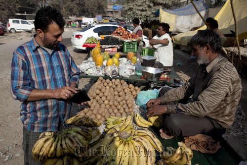 A customer looks at a fruit stall in New Delhi, India. (Bloomerg)