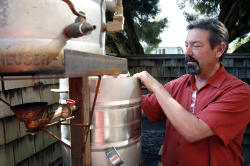 Mark Taylor explains the mechanics of his backyard gravity-fueled beer sculpture at his Capitola, California home. (Santa Cruz Sentinel/MCT)