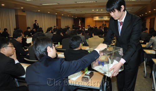 A Hyundai Merchant Marine shareholder casts a ballot on a proposal to increase the preferred stock sales limit at a shareholders meeting Friday. (Park Hyun-koo/The Korea Herald)
