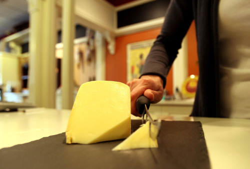 Erika Aylward, co-owner of Boulevard Market, cuts a piece of raw milk gouda cheese at her store in Tecumseh, Michigan, March 17. (Detroit Free Press/MCT)