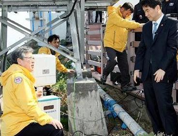 Education, Science and Technology Minister Lee Ju-ho (right) looks at a radiation monitor in Dokdo on Friday.