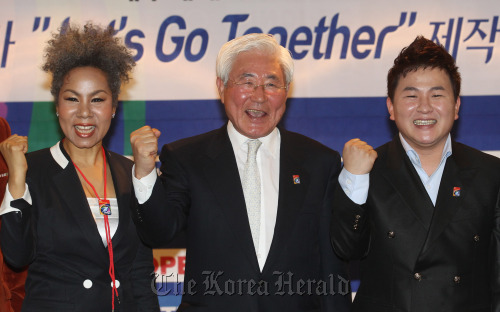 Cho Hae-nyoung (center), co-president of the Organizing Committee for the 2011 IAAF World Championships in Daegu from Aug. 27 to Sept. 4, and singers Insooni (left) and Huh Gak launch the event’s official song at the Press Center in Seoul on Thursday. (Yonhap News)