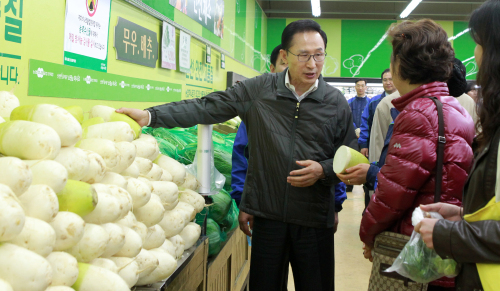 President Lee Myung-bak talks to a shopper about rising prices of farm and fishery products at the Hanaro Club in Seoul on Thursday. (Yonhap News)