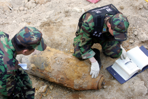 This 2007 file photo shows that soldiers inspect an unidentified explosive discovered at a construction site in Seoul. (The Korea Herald)