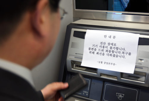 A notice on disruptions to the National Agricultural Cooperative Federation’s computer system is posted on an automated teller machine at one of its branches in Seoul on Wednesday. (Yonhap News)