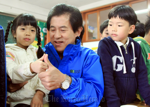 Ohm Ki-young, ruling party candidate for Gangwon governor, talks to children at Pyeongchang Elementary School in Gangwon Province. (Yonhap News)