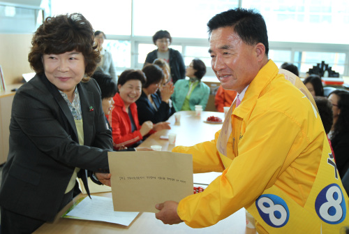 Lee Bong-soo of the People’s Participation Party receives a policy proposal from residents in Gimhae, South Gyeongsang Province, Thursday. (Yonhap News)