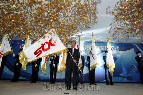 STX Group chief Kang Duk-soo waves the company’s flag at the 10th year celebrations held at the company’s plant in Dalian, China on Friday. (STX Group)