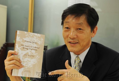 Korean-American journalist Han Woo-sung shows an English translation of his book about Col. Kim Young-oak in Seoul on Wednesday. (Lee Sang-sub/The Korea Herald)