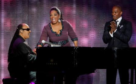 Stevie Wonder (left) performs for Oprah Winfrey as Jamie Foxx looks (right). (AP)