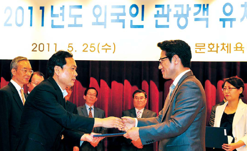 Culture Minister Choung Byoung-gug (right) confers the certificate, “2011 Best Travel Agency Recommended by Ministry of Culture, Sports and Tourism, Korea” to Lotte JTB’s planning team general manager Eun Yong-woong in Seoul on Wednesday. (Kim Myung-sub/The Korea Herald)