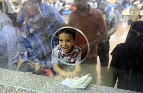 Palestinian Mohammed Ahmed holds his father’s passport at the Egyptian passport administration at Rafah crossing port on Saturday. (AP-Yonhap News)